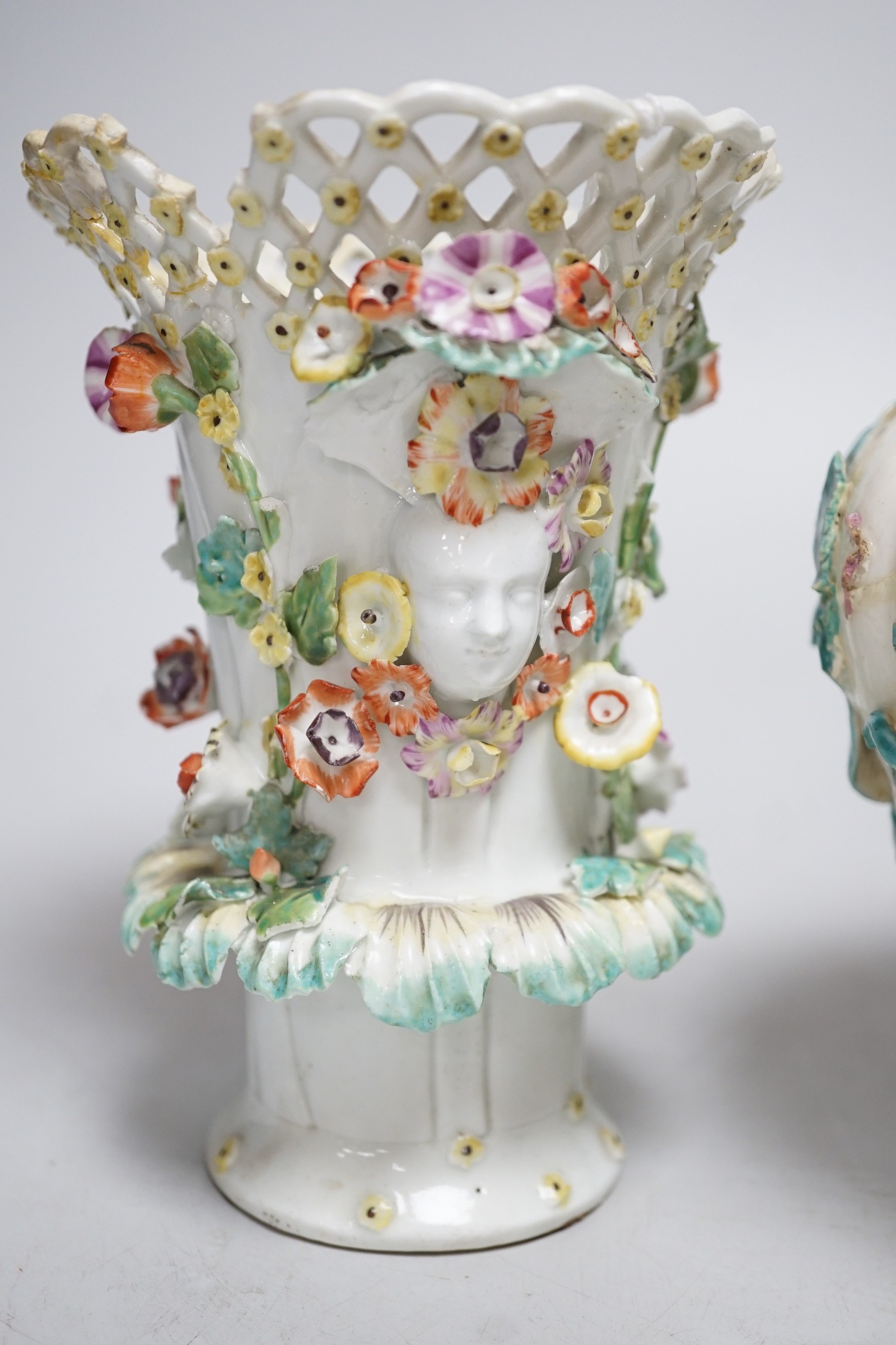 An 18th century Chelsea pot pourri vase, red anchor period, encrusted and painted with leaves and flowers and a Bow frill vase with mask heads encrusted with flowers. Tallest 16.5cm
